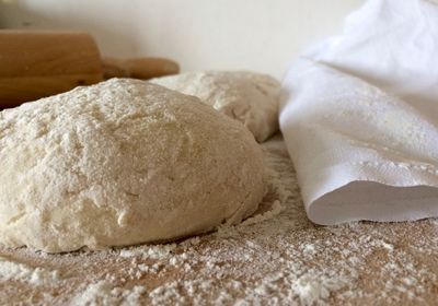 Close-up of dough and flour on kitchen counter
