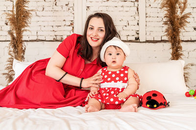 Portrait of mother and daughter on bed