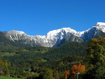 Scenic view of snowcapped mountains against clear blue sky