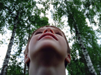 Low angle of boy against trees