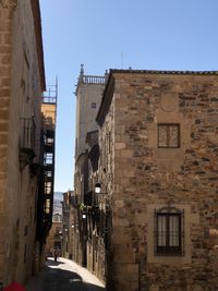 Street amidst buildings in town against clear sky