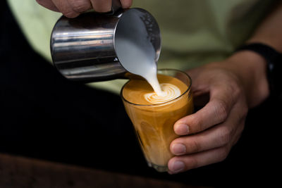 Midsection of person preparing coffee