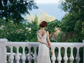 Woman standing by railing on balcony