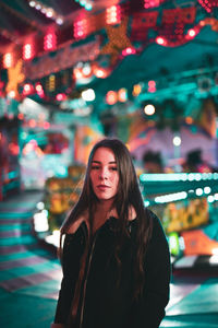 Portrait of beautiful young woman standing at night