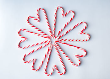 Candy canes arranged in heart shapes on a plain white background.