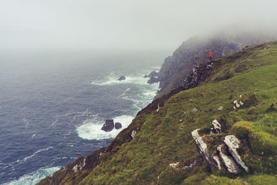 Scenic view of sea by mountains against sky