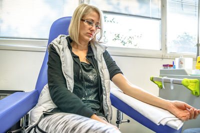 Woman sitting for blood test at hospital 