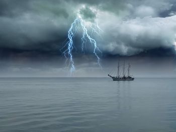 Ship in sea against storm clouds