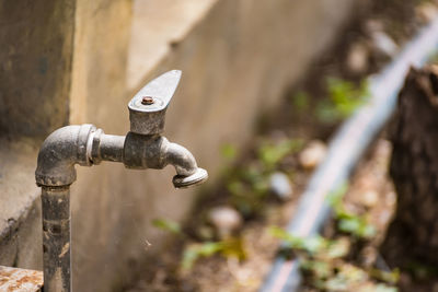 Close-up of old faucet against wall