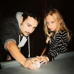 Portrait of daughter with father playing pool