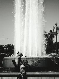 Water splashing in fountain against clear sky