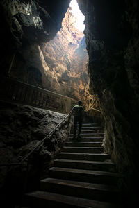 Rear view of person standing in cave