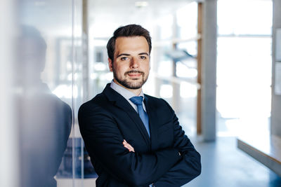 Portrait of man with arms outstretched standing against wall