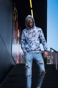 Portrait of young man standing against built structure