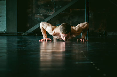 Shirtless man exercising on floor