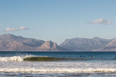 Scenic view of sea and mountains against sky