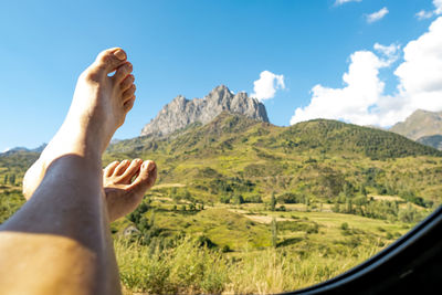 Close-up of a girl's feet in a window with a mountain in the background