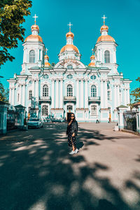 Woman in front of building against sky in city