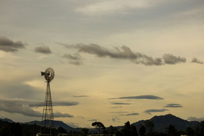 Low angle view of silhouette windmills against sky during sunset