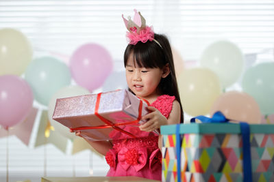 Girl holding gift during birthday at home