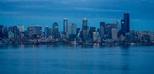 View of sea and buildings against sky in city