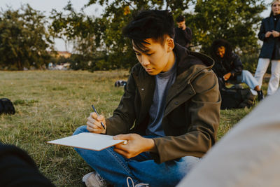 Young man sitting on field