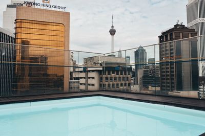 View of swimming pool against buildings in city