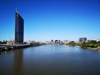 Modern buildings in city against clear blue sky