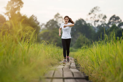 Portrait of young woman standing on field