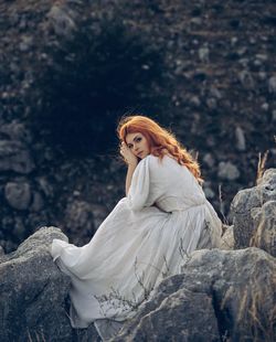 Portrait of woman standing against rock