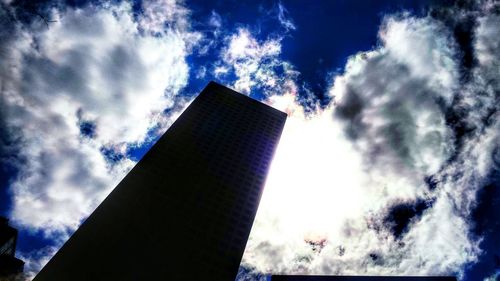 Low angle view of modern building against cloudy sky