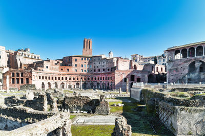 Buildings in city against clear blue sky