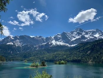 Scenic view of lake by mountains against sky