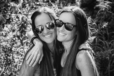 Portrait of smiling young woman wearing sunglasses outdoors