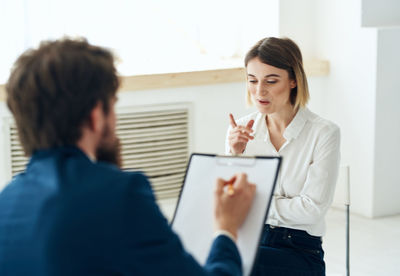 Businesswoman using mobile phone while sitting at office