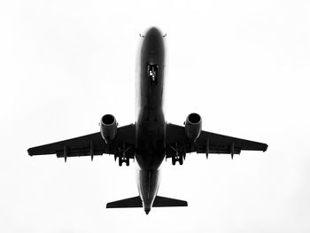 Low angle view of airplane flying against clear sky