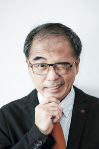 Portrait of man wearing eyeglasses against white background