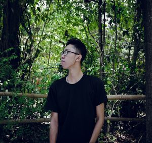 Young man looking away in forest