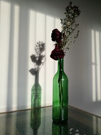 Red rose in glass vase on table