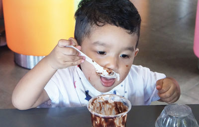 Boy eating ice cream on table