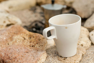 Close-up of coffee cup on rock