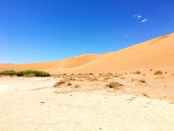 View of desert against clear blue sky