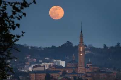 Universidad laboral building in gijón city at night with full moon