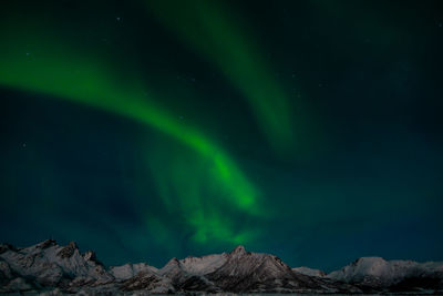 Scenic view of snowcapped mountains against sky at night