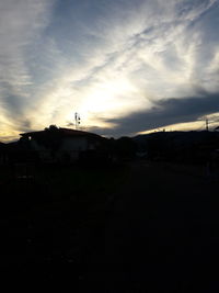 Silhouette buildings in city against sky at sunset