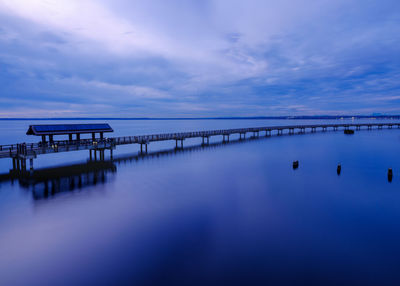 Pier on sea against sky at sunset