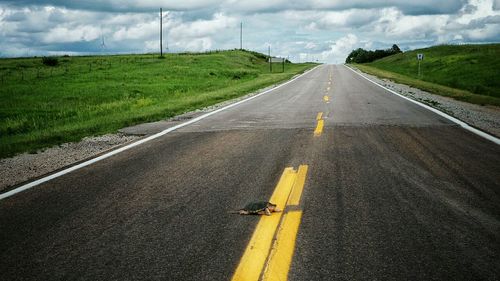 Empty road against cloudy sky