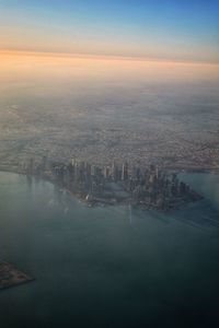 Aerial view of city buildings against sky during sunset