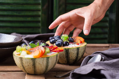 Midsection of person with fruits on table