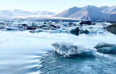 Scenic view of frozen lake against mountain range and sky